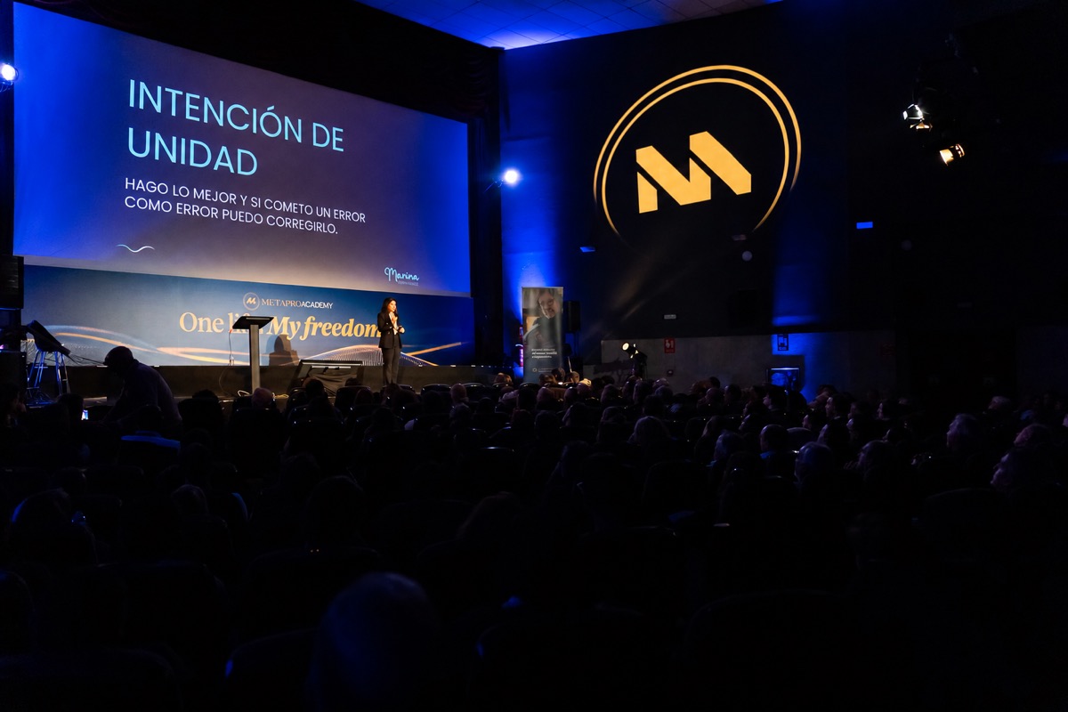 Marina Berenguer en el escenario del Summit'25 de MetaPro Academy, con la diapositiva «Intención de unidad»